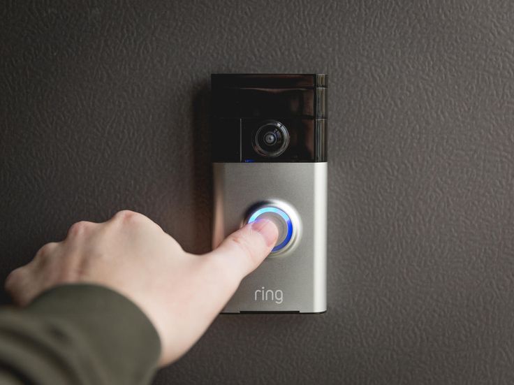 man pressing thumb on door bell entry system